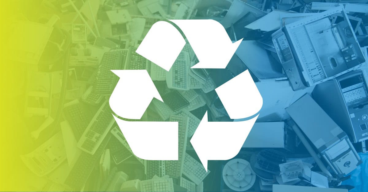 Pile of discarded computers with recycle symbol.